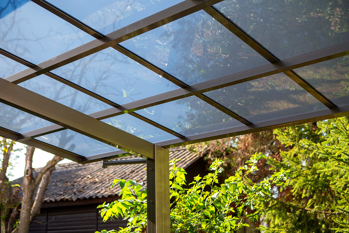 Előregyártott kocsibeálló alumínium vázzal és polikarbonát tetővel.