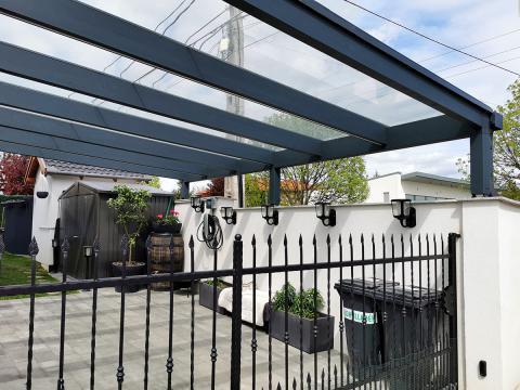 Modern, üvegfedésű kocsibeálló, ragasztott fa szerkezettel