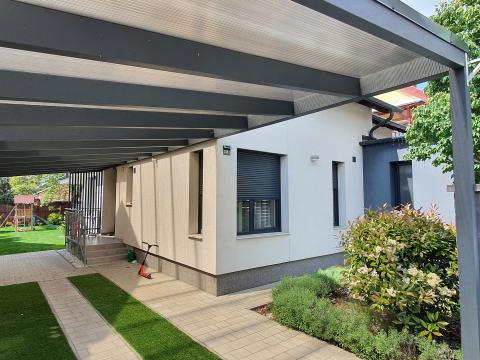 Falhoz rögzített, ragasztott fa szerkezetű polikarbonát fedésű kocsibeálló 01