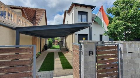 Falhoz rögzített, ragasztott fa szerkezetű polikarbonát fedésű kocsibeálló 02