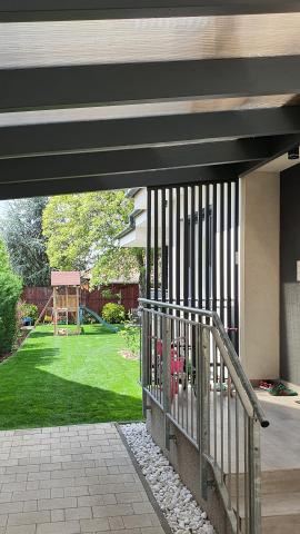 Falhoz rögzített, ragasztott fa szerkezetű polikarbonát fedésű kocsibeálló 07