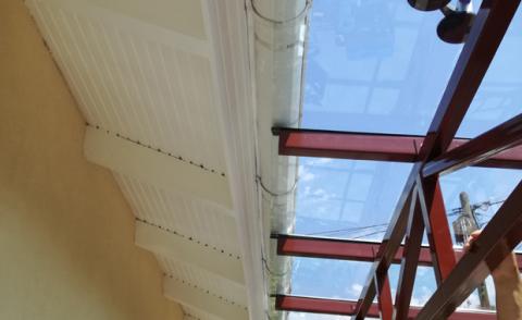 Porfestett acél tartószerkezet rácsostartóval + ragasztott biztonsági üveg fedéssel készült autóbeálló