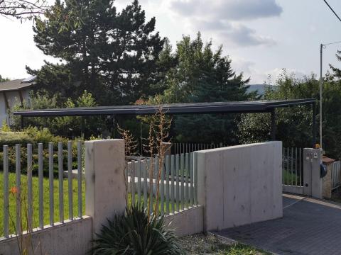 Napelem fedésű autóbeálló vasszerkezettel