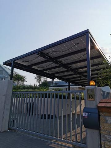 Napelem fedésű autóbeálló vasszerkezettel