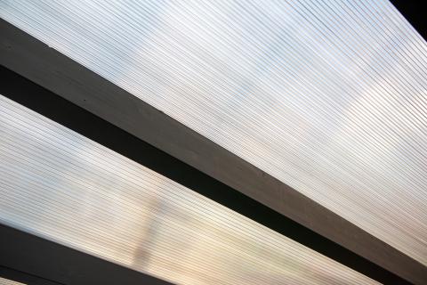 Napelemekkel fedett, extra hosszú, négy állásos kocsibeálló rétegragasztott fa szerkezettel.